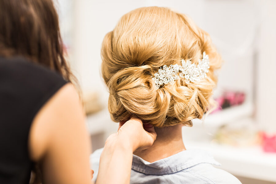 Portrait of attractive young woman with beautiful hairstyle and stylish hair accessory, rear view
