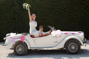 Newlyweds leaving for honeymoon in vintage car