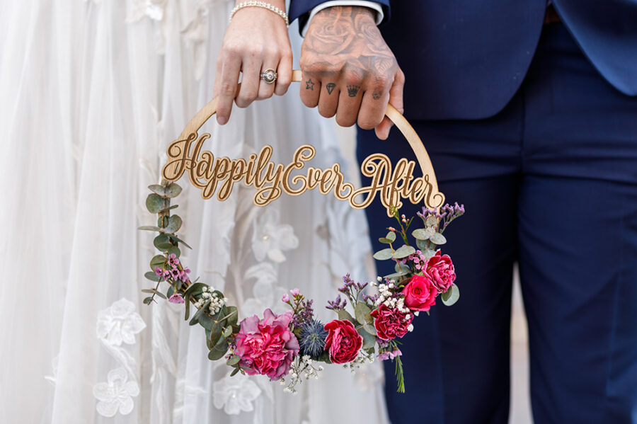 Couple holding Happily Ever After wreath after getting married