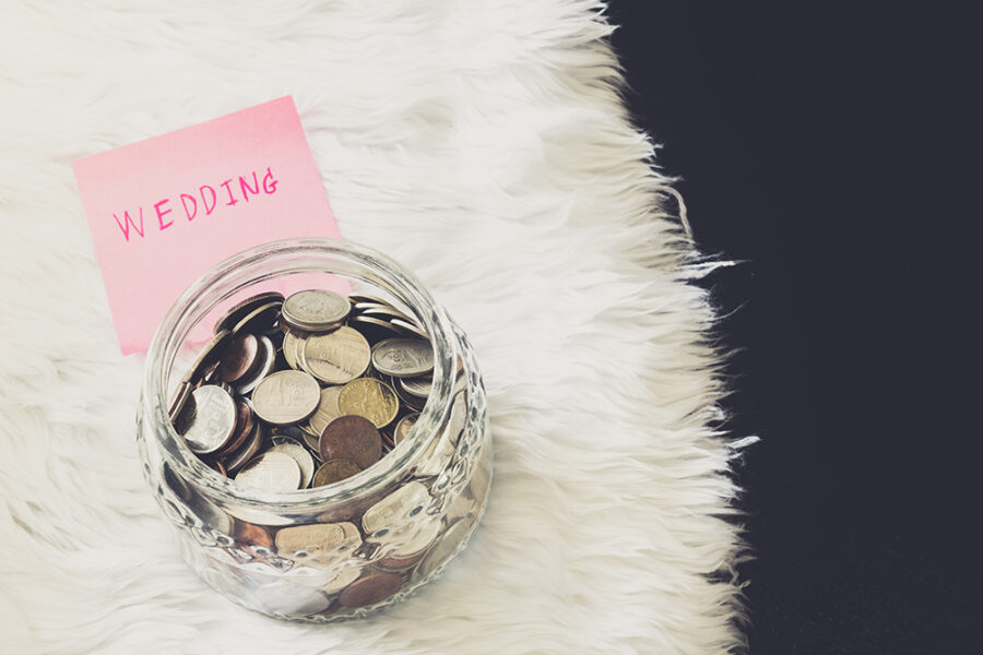 many coins in a money jar with wedding label on jar. wedding concept. saving concept