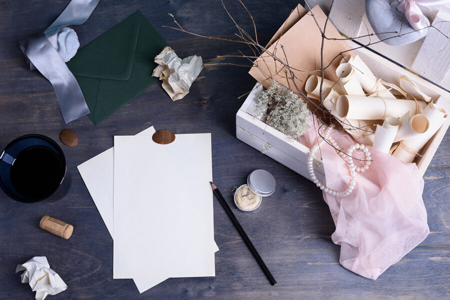 Mix of stationery objects and accessories on a wooden table background. Wedding invitations mockup concept. Wedding day composition - office desk. Studio shot on wooden background. View from above.