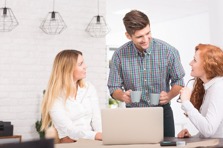 Handsome man serving coffee for his friends in the office