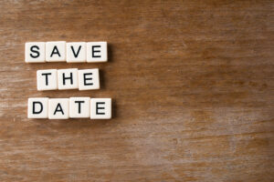 Save the date spelled out on a wooden background.