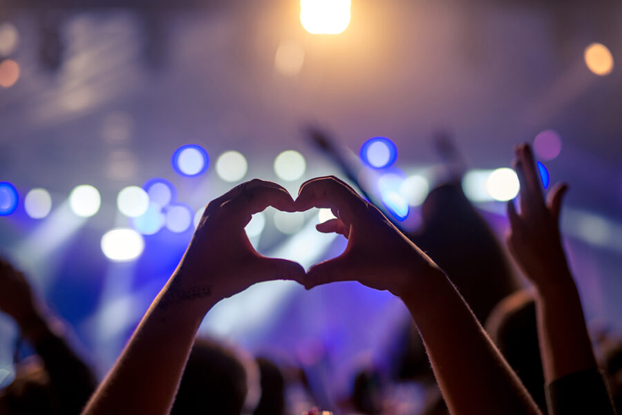 Girl showing heart while partying on a festival.