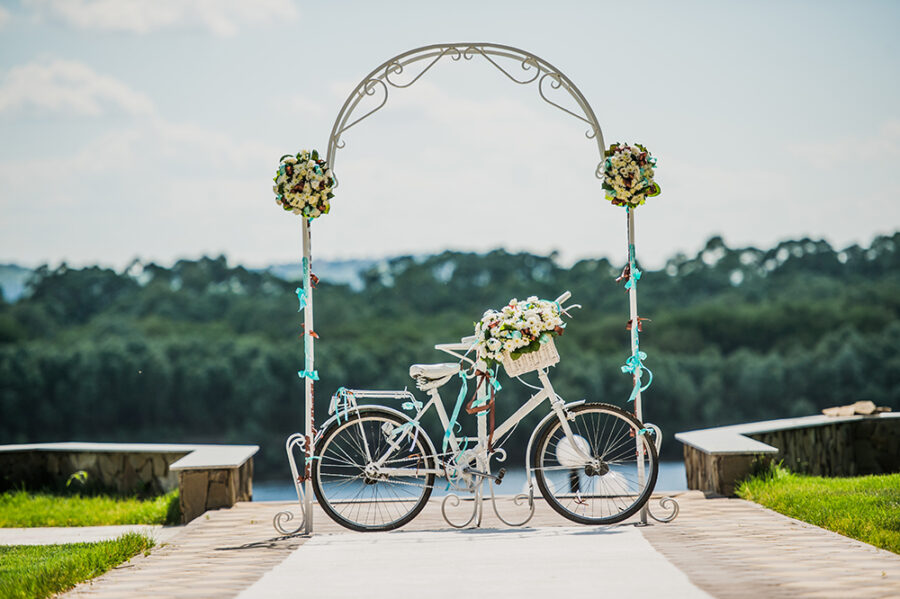 White and blue arch decorated with flowers bycicle, wedding registration outdoors.